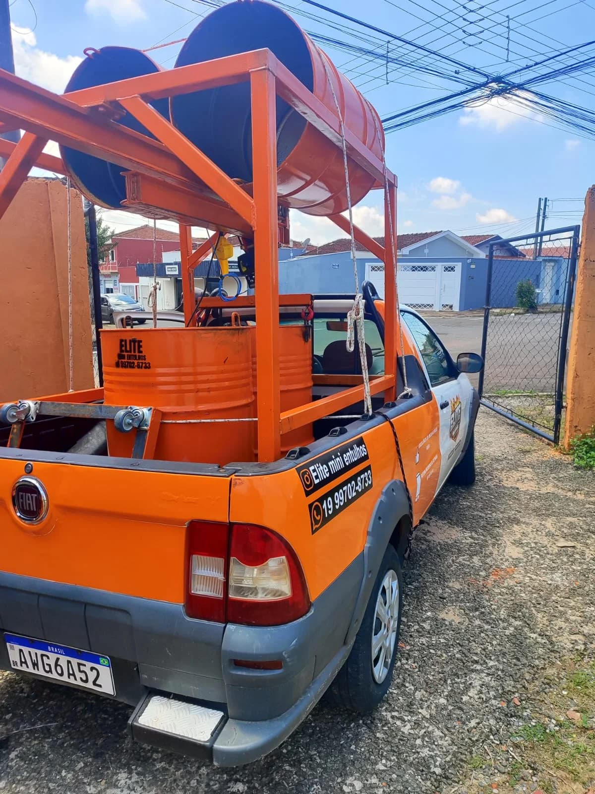 Parte traseira da picape da Elite com coletores laranja e equipamento de elevação